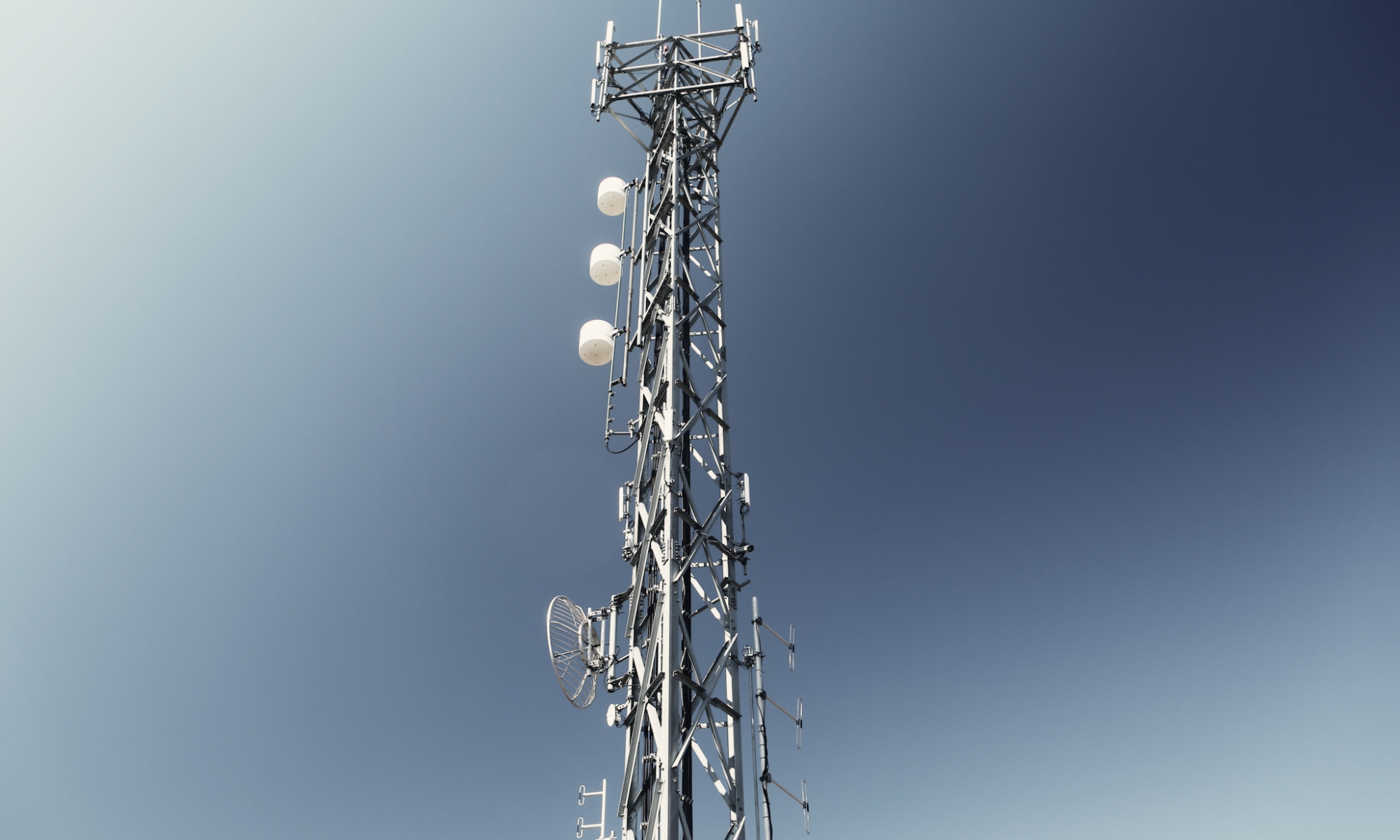 A cell tower with a blue sky in the background.